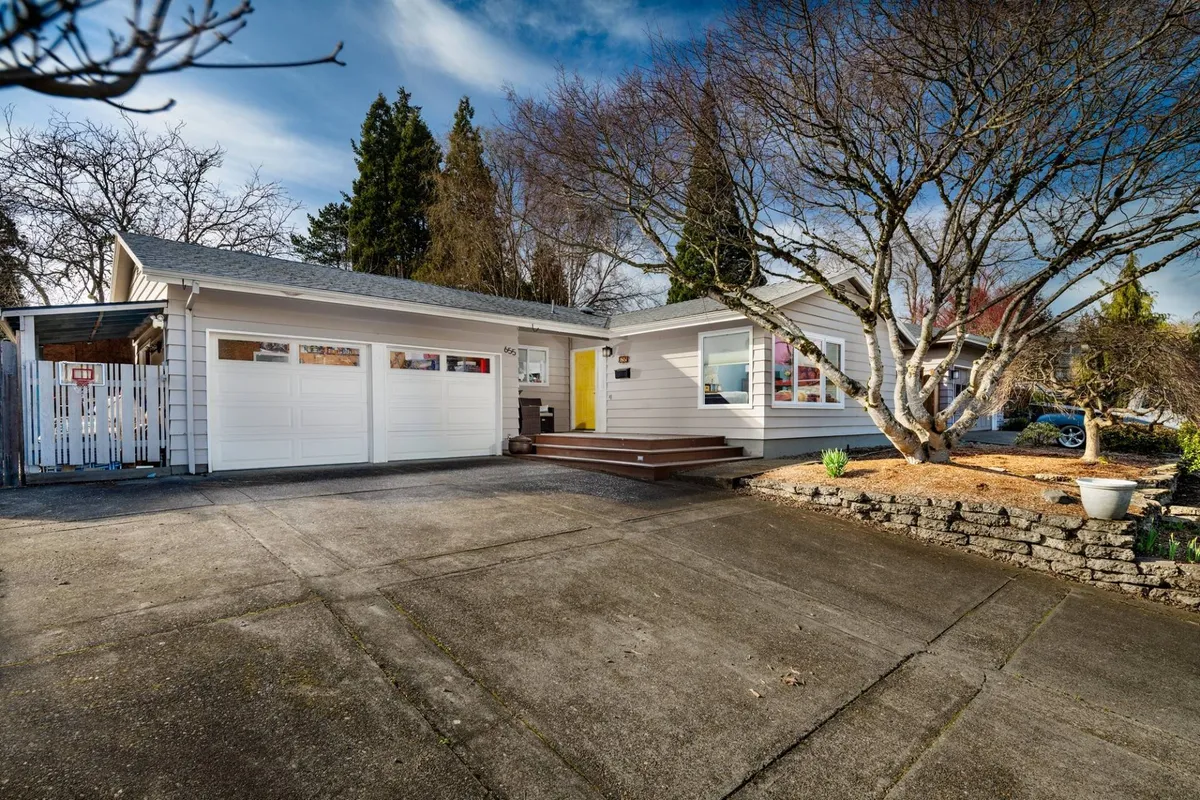 This image showcases the front exterior of the home, featuring a bright front door, a well-kept garage, landscaped yard, and a mature tree. The inviting entryway sets a welcoming tone for families embarking on their stay.